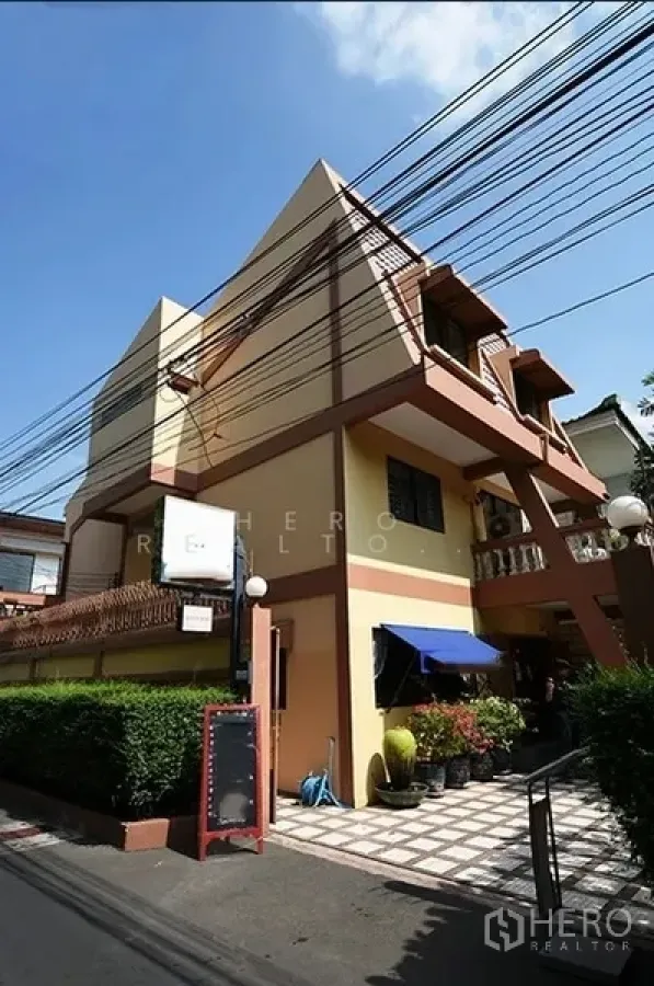 独立式住宅 出租在Watthana, Bangkok - 瓦他那区三层独栋住宅，几何外立面，带阳台与遮阳篷，临静巷的铺砖入口。