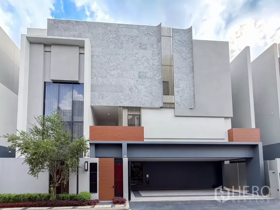 Detached House for rent or sale in Bang Kapi, Bangkok - Modern three-storey facade with marble cladding, wide driveway and covered double garage.