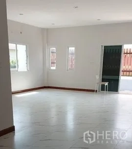 Warehouse for rent in Lam Luk Ka, Pathum Thani - Bright ground-floor office with white tiled floors, multiple windows and a front door.