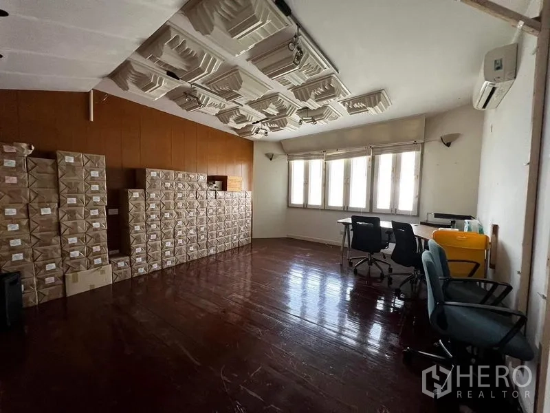 Townhouse for rent - Large storage or studio room with acoustic panels and stacked boxes.