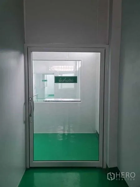 Factory for sale in Bang Pa-in, Phra Nakhon Si Ayutthaya - Doorway to the production zone viewed from a narrow white corridor.