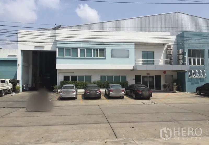工厂 出租或出售在Bang Phli, Samut Prakan - 邦普利两层工厂外观，前方停车位与大型卷帘装卸门