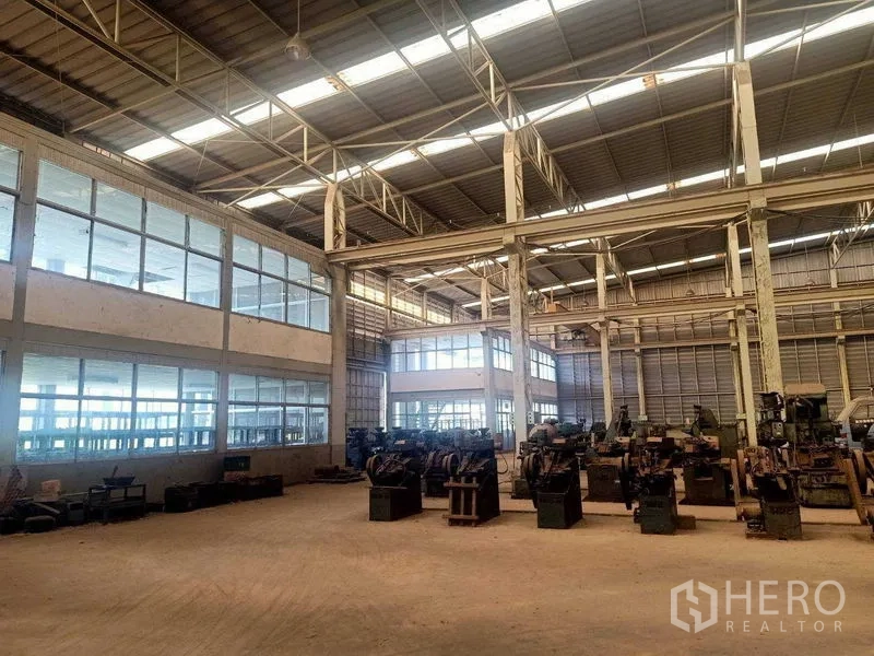 Warehouse for rent in Mueang Samut Sakhon, Samut Sakhon - Spacious warehouse interior with high steel roof, skylights and glass-walled office rooms.