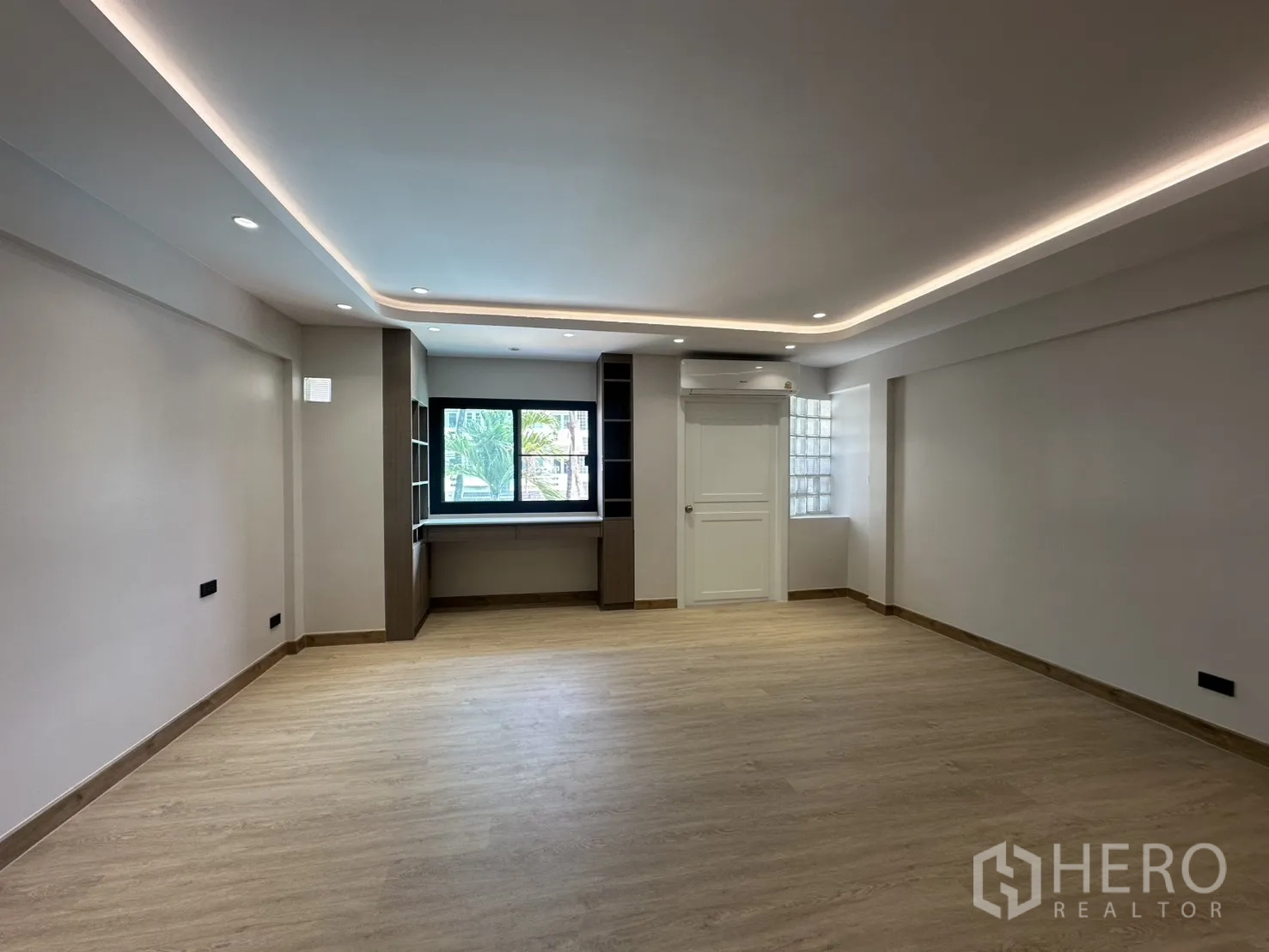 Home Office for rent in Watthana, Bangkok - Bright multipurpose room with wood floors and a built-in desk by the window.