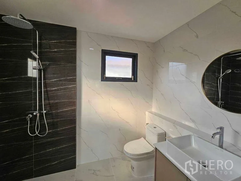 Detached House for sale in Thanyaburi, Pathum Thani - Contemporary bathroom with rain shower, black feature wall, and vanity.