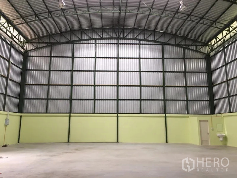 Warehouse for rent in Lat Krabang, Bangkok - Straight-on interior shot featuring arched roof, ribbed metal walls, utility room and sink.