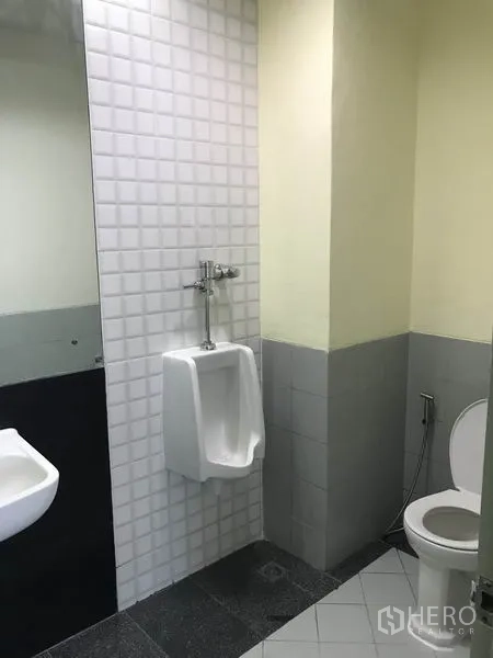 Office Space for rent in Khlong Toei, Bangkok - Restroom with urinal, toilet, sink, and tiled walls.