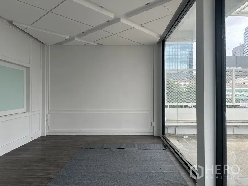 Retail Space for rent in Bang Rak, Bangkok - Interior corner with floor-to-ceiling glass overlooking the terrace and towers.