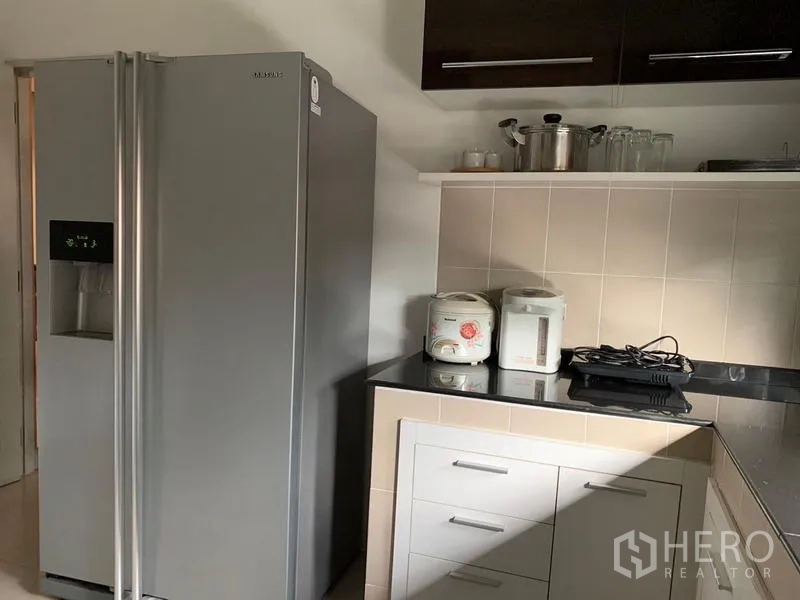 Detached House for rent or sale in Khan Na Yao, Bangkok - Kitchen corner with side-by-side refrigerator and additional storage.