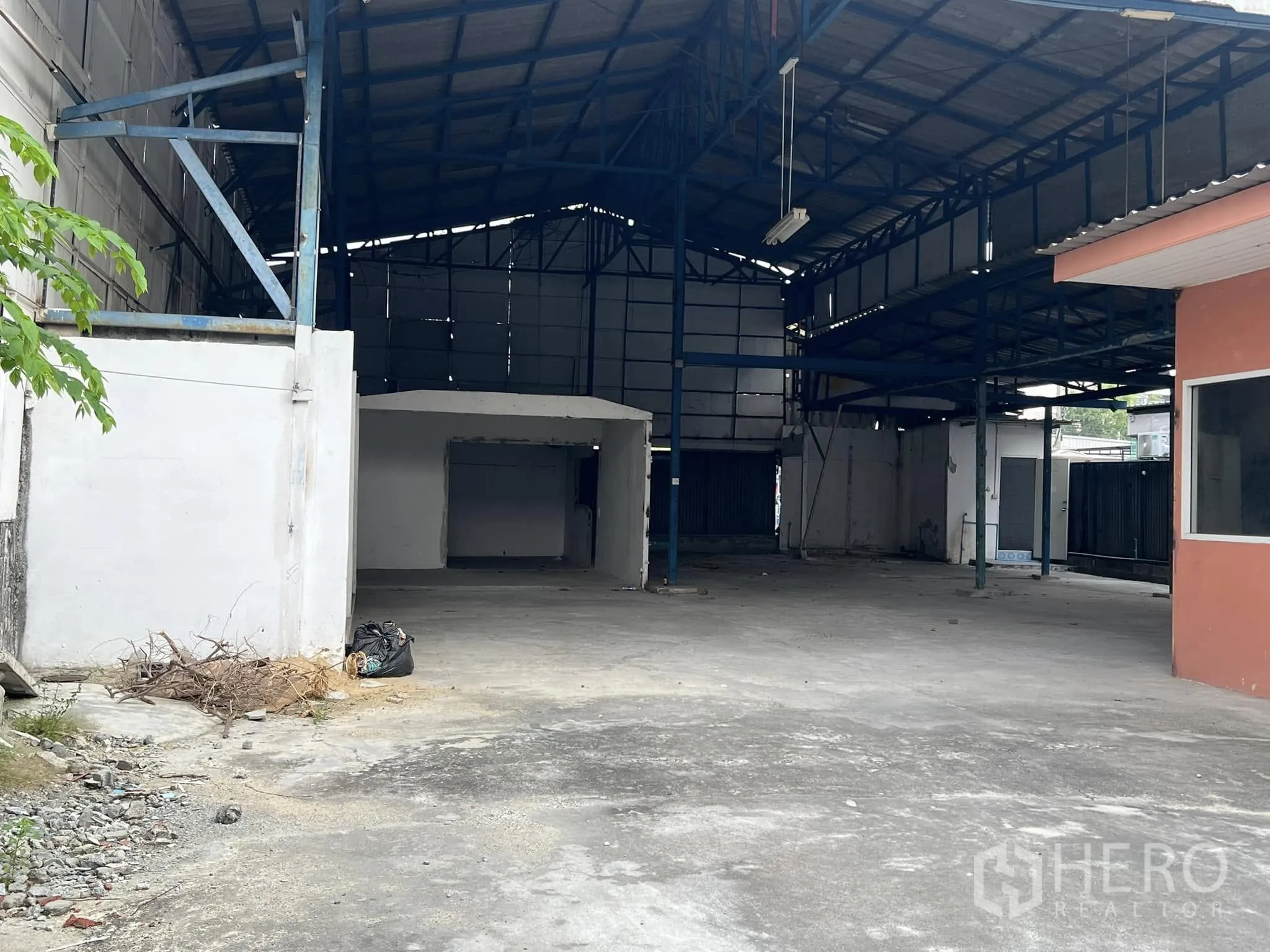 Warehouse for rent in Lat Phrao, Bangkok - Closer look into the covered warehouse bay with steel trusses and open concrete floor.
