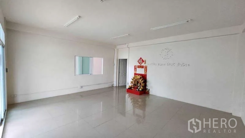 Factory for rent in Samut Sakhon - Spacious ground-floor office with glossy tiled floor and natural light.