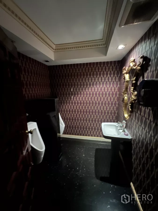 Retail Space for rent in Watthana, Bangkok - Restroom with patterned wallpaper, gold-framed mirror, urinals and sink.