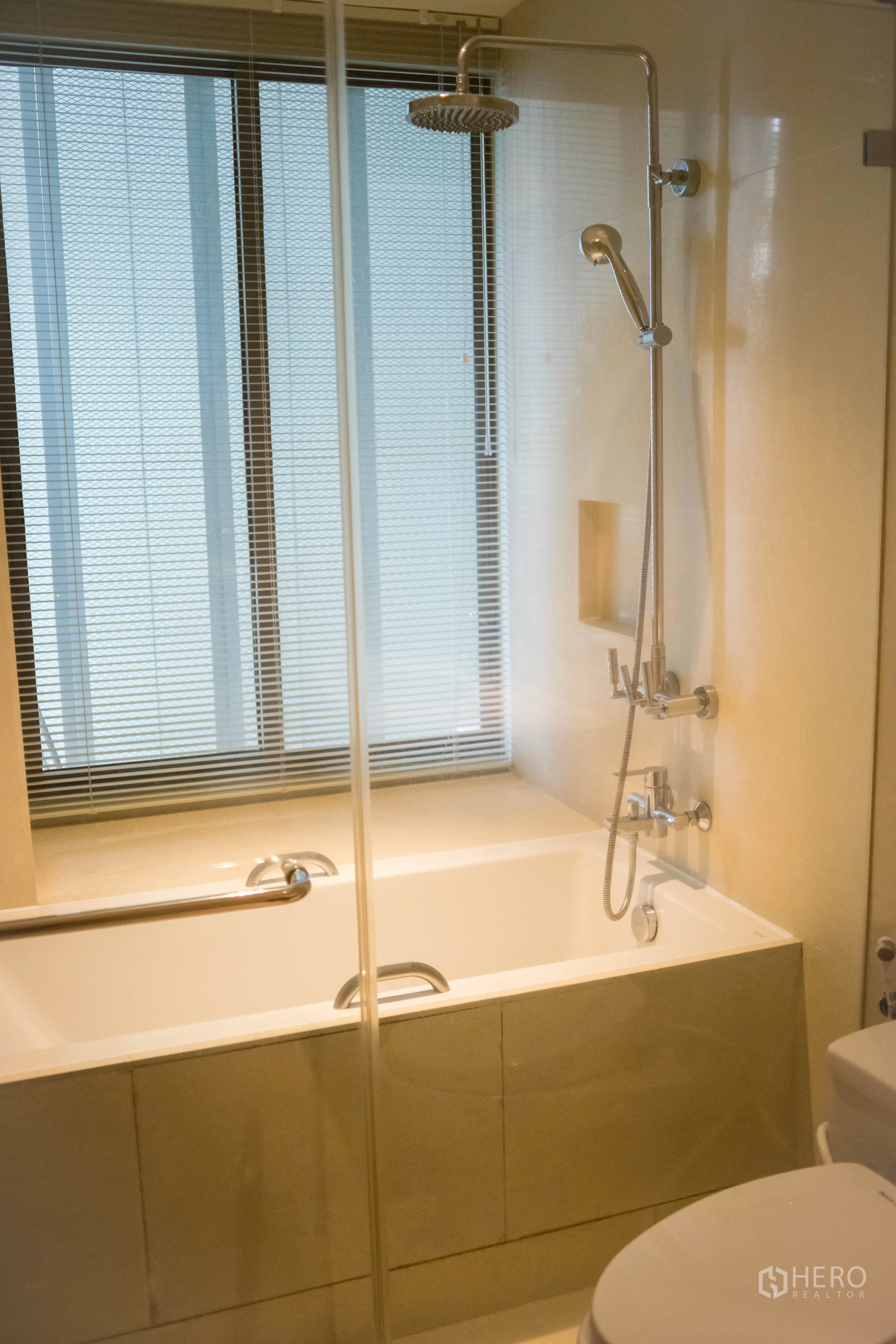 Condominium for rent or sale in Khlong Toei, Bangkok - Bathroom with bathtub, glass shower screen, rain shower and handheld sprayer.