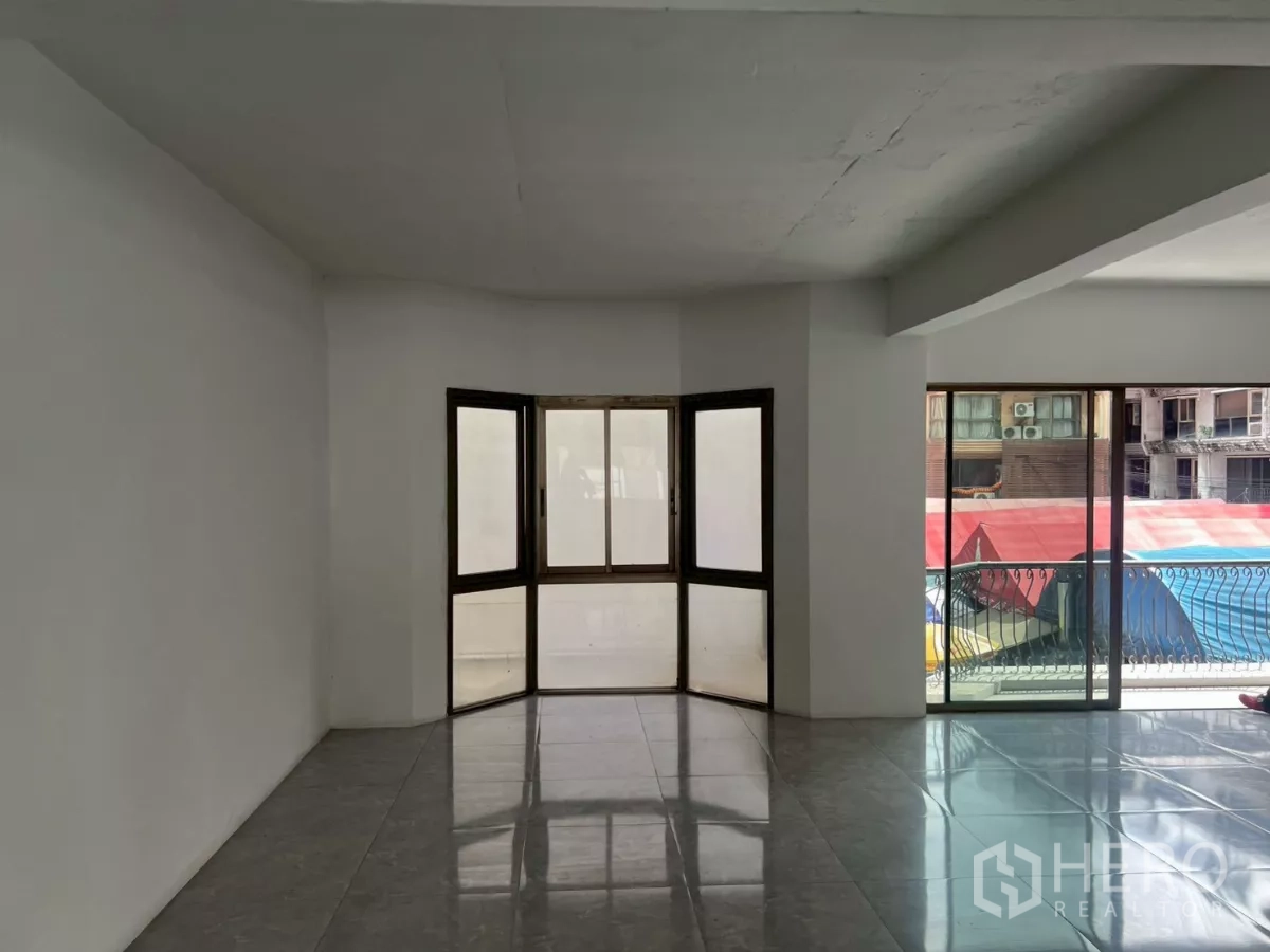 Retail Space for rent in Pathum Wan, Bangkok - Bay window nook and sliding door to a balcony with views of neighboring buildings.