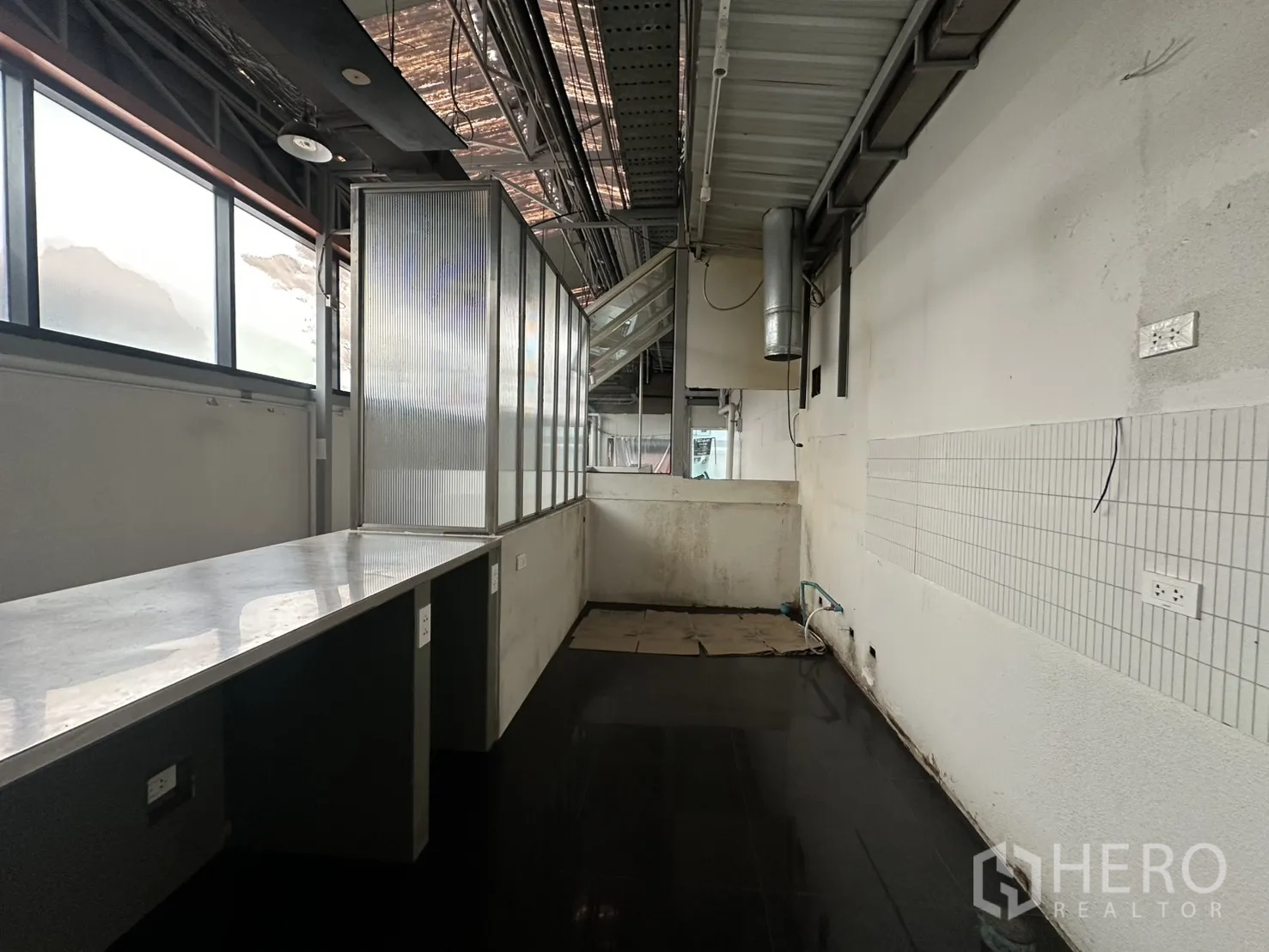 Retail Space for rent in Bang Rak, Bangkok - Long countertop facing frosted windows with utility outlets along the wall.