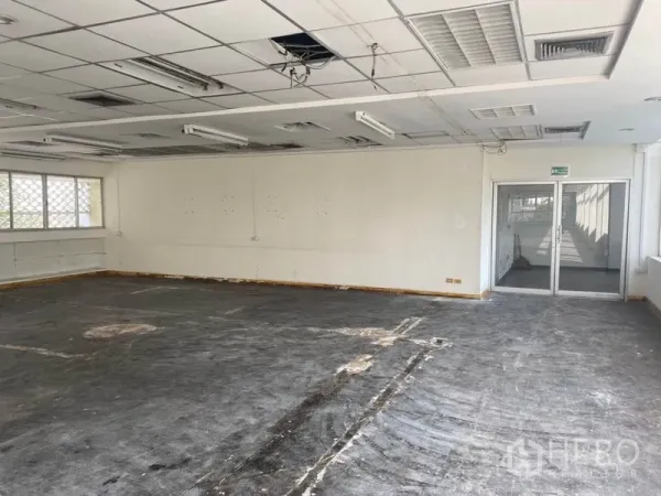 Office Space for rent in Khlong Toei, Bangkok - Open office in shell condition with sliding glass entry doors and acoustic ceiling panels.
