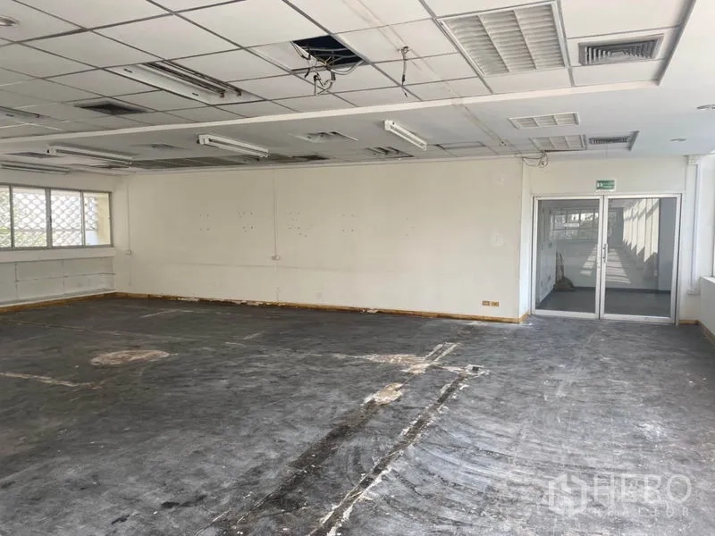 Office Space for rent in Khlong Toei, Bangkok - Open office in shell condition with sliding glass entry doors and acoustic ceiling panels.