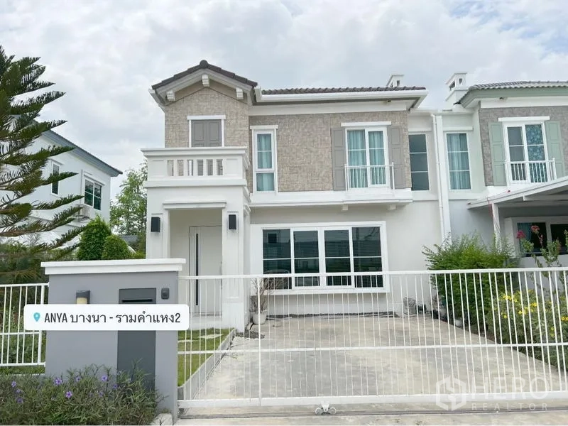 Detached House for rent or sale in Prawet, Bangkok - Front elevation of the house showing driveway, fence and landscaped hedges.