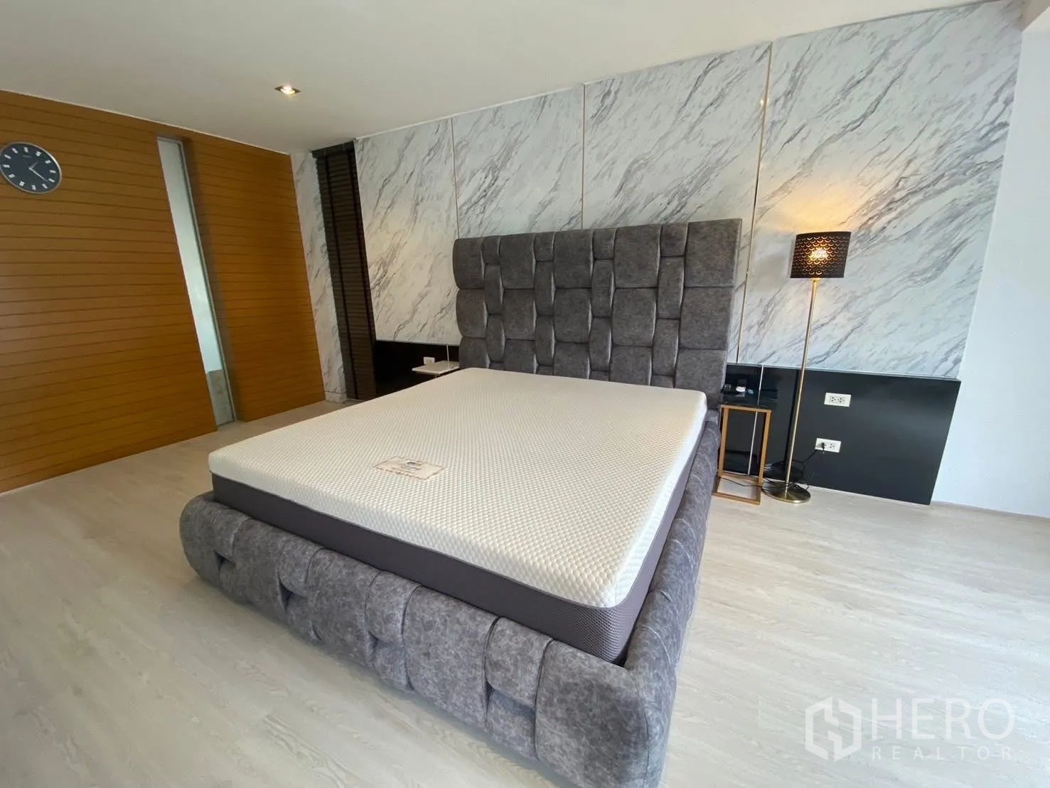 Detached House for rent in Suan Luang, Bangkok - Bedroom with a marble accent wall and upholstered platform bed.