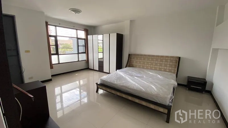 Townhouse for rent in Bang Na, Bangkok - Sunlit bedroom with double bed, wardrobe and large window.