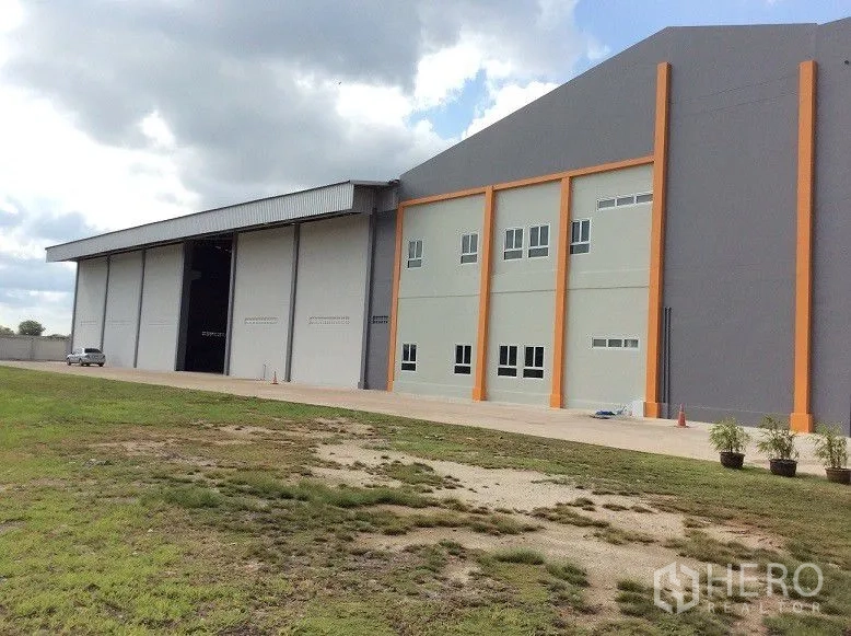 Factory for sale in Bang Sao Thong, Samut Prakan - Warehouse exterior with tall roller doors and orange columns.