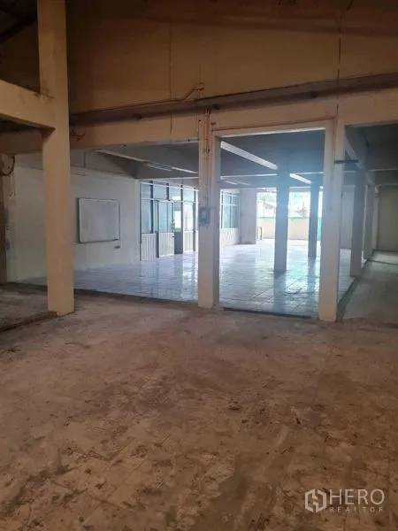Warehouse for rent in Bang Yai, Nonthaburi - Warehouse aisle opening to a tiled area through wide doorway and glass partitions.