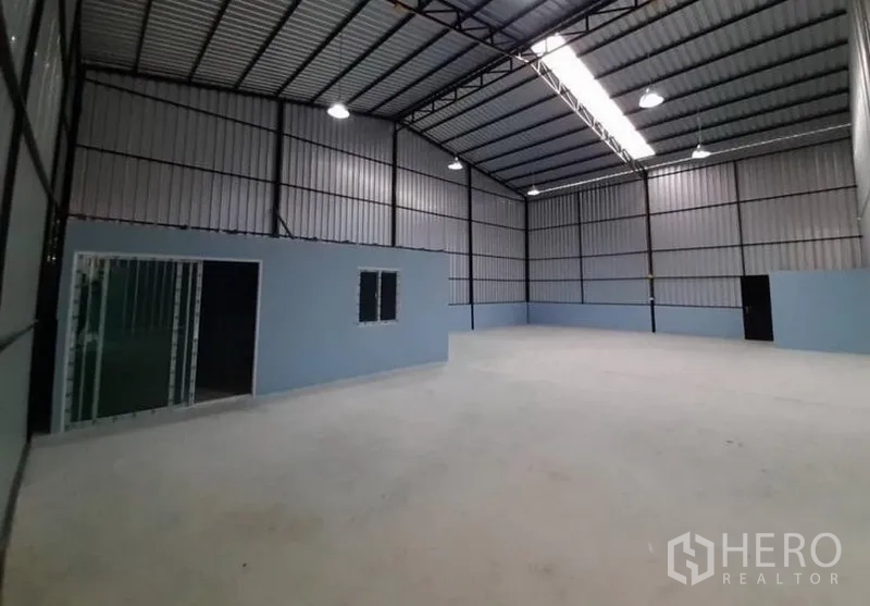 货栈 出租在Lam Luk Ka, Pathum Thani - 开阔储存区，可见办公室模块、天窗采光带及高棚灯。