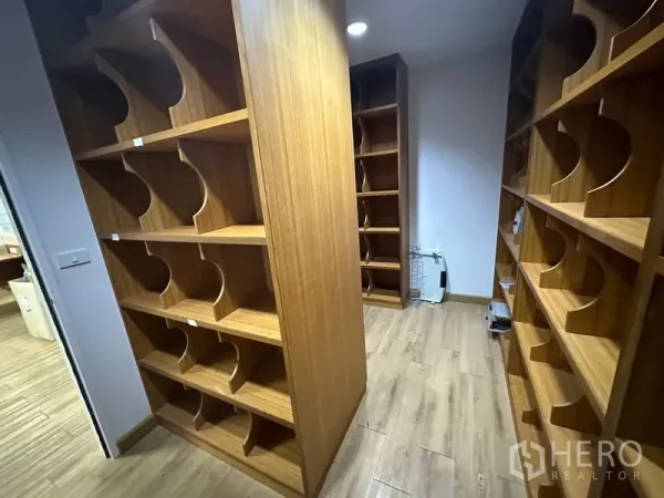 Office Space for rent or sale - Archive room with built-in wooden shelving and wood floors.