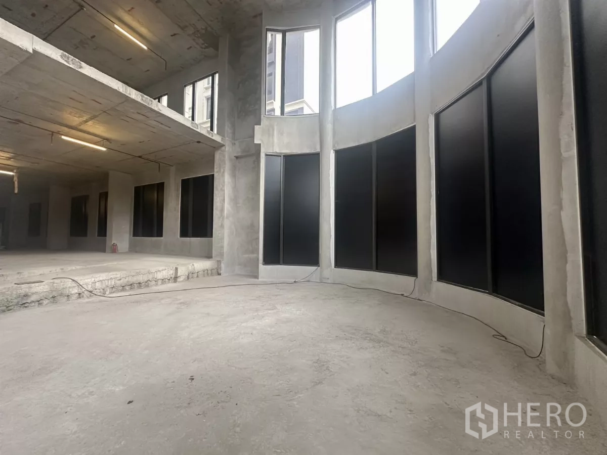 Retail Space for rent in Watthana, Bangkok - Large shell retail unit with high ceiling and curved floor-to-ceiling window frontage.
