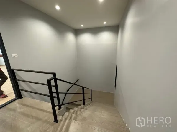 Factory for rent or sale in Lam Luk Ka, Pathum Thani - Clean stairwell in the office block featuring tiled steps, downlights and a black metal handrail.