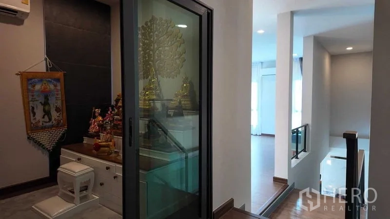 独立式住宅 出租或出售在Bang Na, Bangkok - 二层过道，带玻璃门的祈祷/冥想室与楼梯相邻。