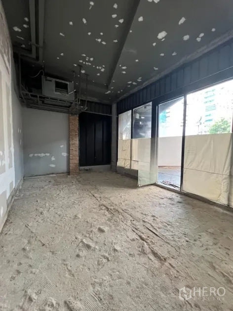 Retail Space for rent in Khlong Toei, Bangkok - Unfurnished retail interior with high ceiling, exposed ducting and floor-to-ceiling windows.