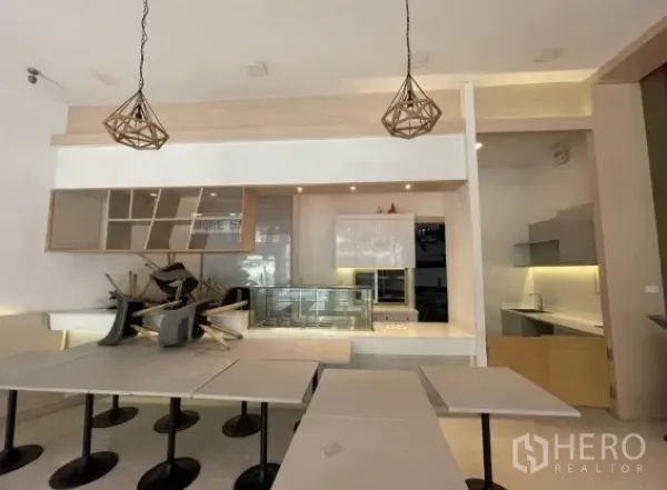 Retail Space for rent in Khlong Toei, Bangkok - Service counter with display case, shelving, and pendant lighting in the front-of-house area.