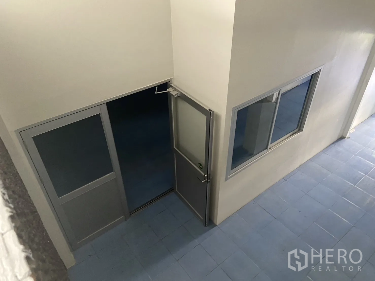 Shophouse for rent in Bang Na, Bangkok - Interior view from above showing an enclosed office room with aluminum doors and windows.