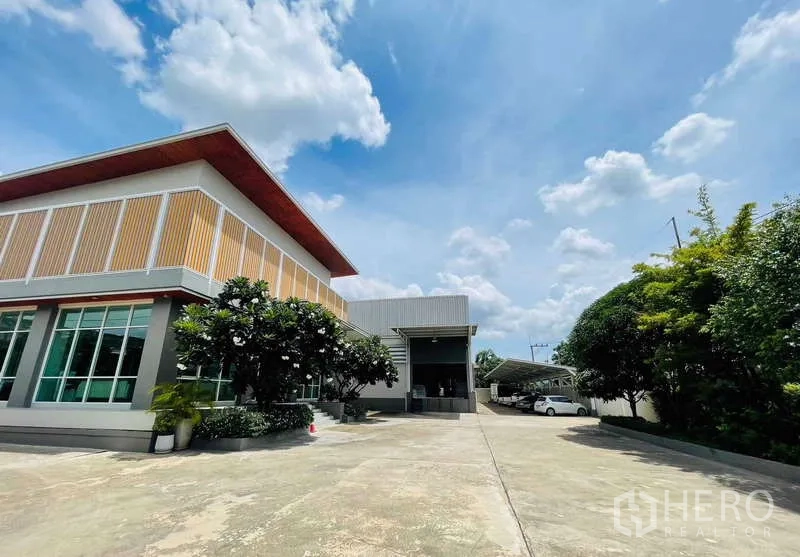 Factory for sale in Krathum Baen, Samut Sakhon - Office and factory complex with a long driveway leading to a loading bay and covered parking.