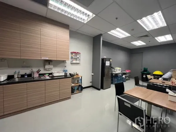 Office Space for rent in Huai Khwang, Bangkok - Staff pantry with wood cabinets, sink, fridge and dining tables.