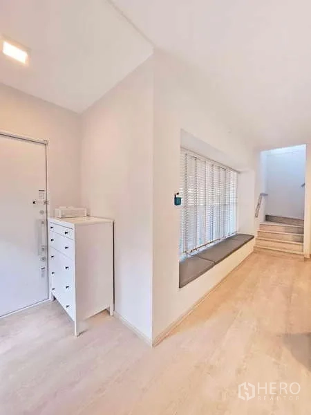Detached House for rent or sale in Prawet, Bangkok - Entry hallway with window bench, chest of drawers and stairs leading up.