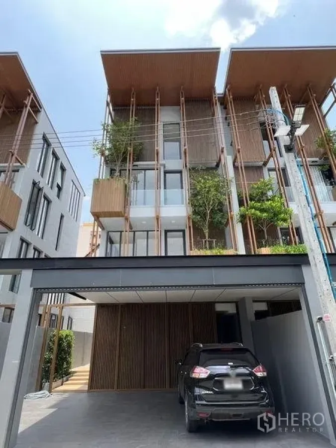 Home Office for sale in Wang Thonglang, Bangkok - Contemporary townhouse exterior with vertical wooden fins, planters, and a covered two-car carport.