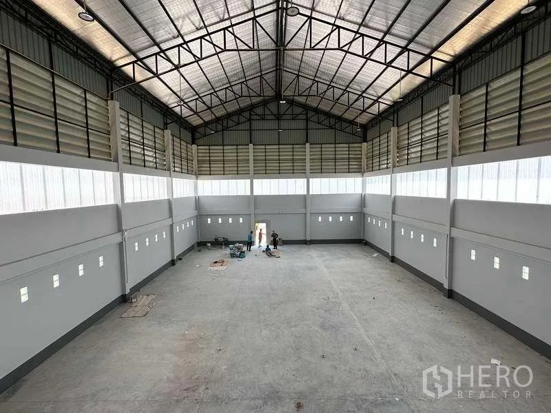 工厂 出售在Khlong Luang, Pathum Thani - 从夹层俯瞰宽阔生产车间，钢桁架屋顶与侧窗。