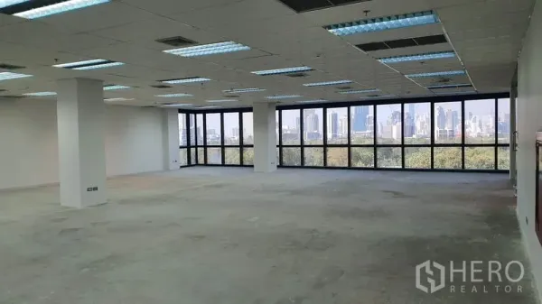 Office Space for rent in Watthana, Bangkok - Expansive office floor with ceiling lighting and panoramic park and city views.