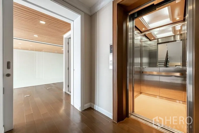Townhouse for rent in Khlong Toei, Bangkok - Private residential elevator next to a room with wood floors and timber ceiling.