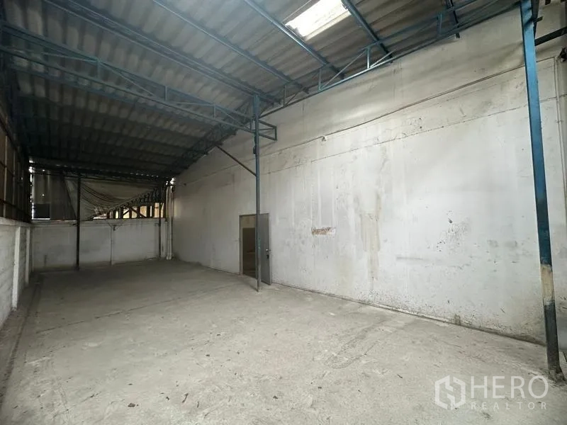 Factory for rent in Khlong Luang, Pathum Thani - Covered rear storage bay with metal roof, columns and concrete floor.