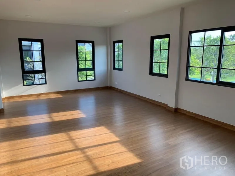 Detached House for rent or sale in Bang Phli, Samut Prakan - Large corner bedroom with multiple windows and wood floors