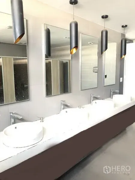 Office Space for rent in Suan Luang, Bangkok - Modern shared restroom area with multiple vessel sinks, mirrors, and black pendant lights.