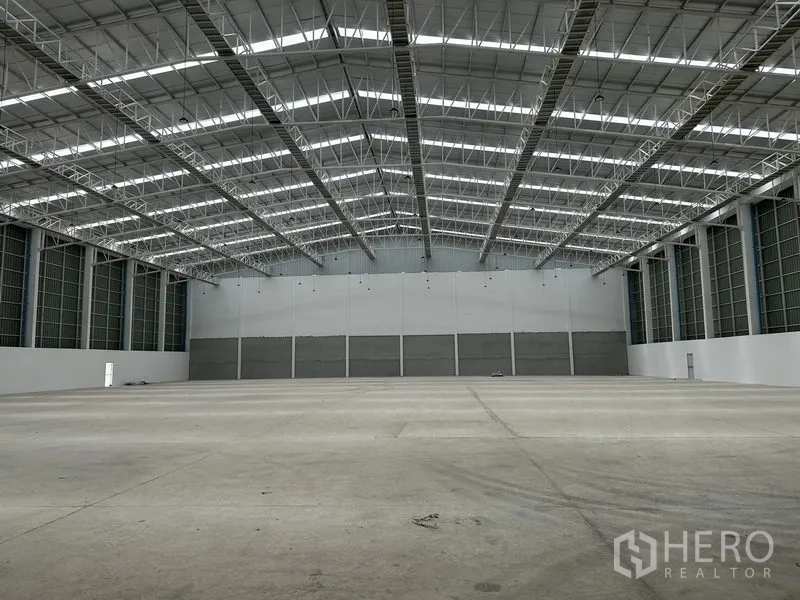 工厂 出租在Pathum Thani - 仓库内部空旷，高墙体与大跨结构。