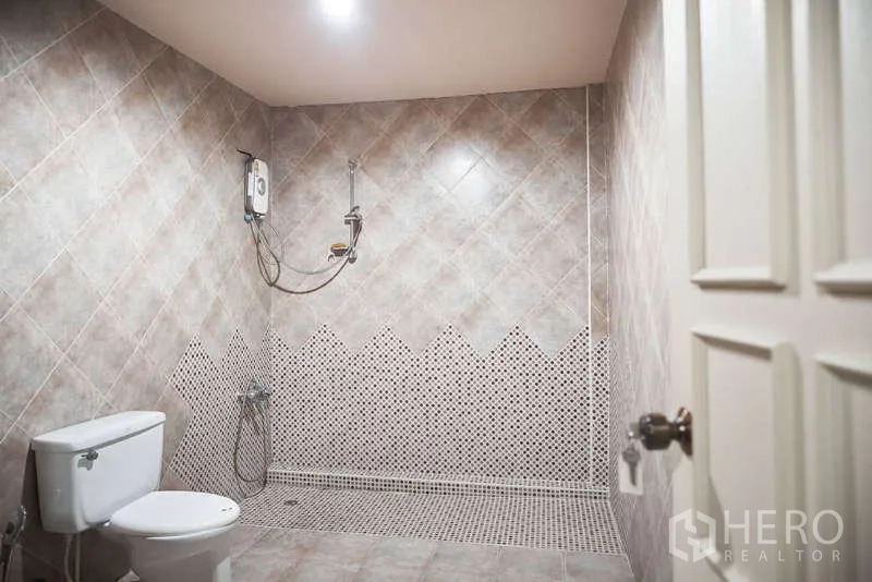 Townhouse for rent in Khlong Toei, Bangkok - Spacious tiled bathroom with walk‑in shower and water heater