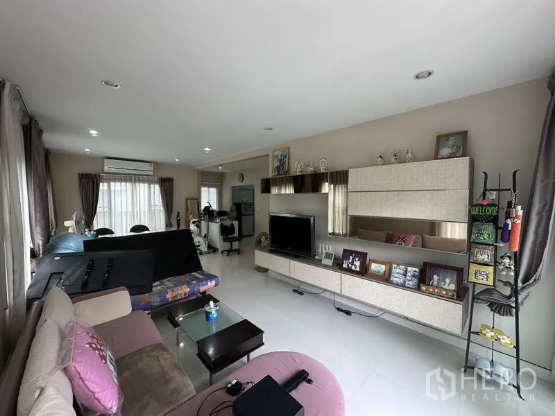独立式住宅 出售在Sai Mai, Bangkok - 明亮起居区，开放式柜架与电视柜、座椅。