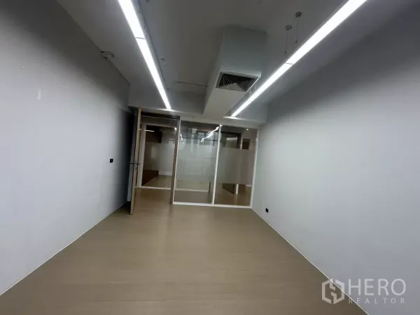 Office Space for rent in Watthana, Bangkok - Enclosed office with linear lights, glass door, and wood-look flooring.