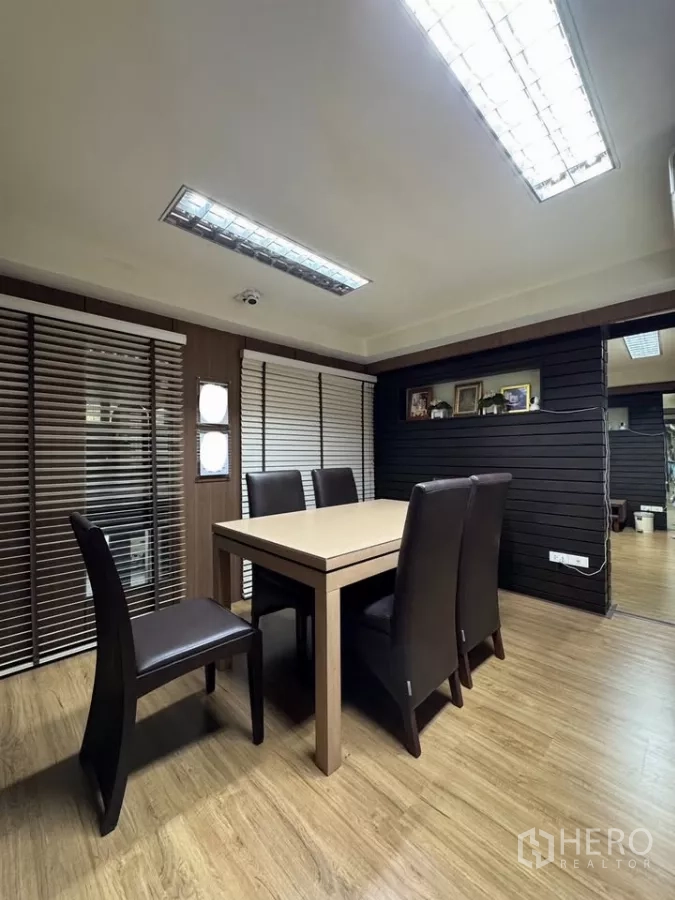 Shophouse for rent in Bang Rak, Bangkok - Meeting or dining room with wood floors, table, and leather chairs with blinds.