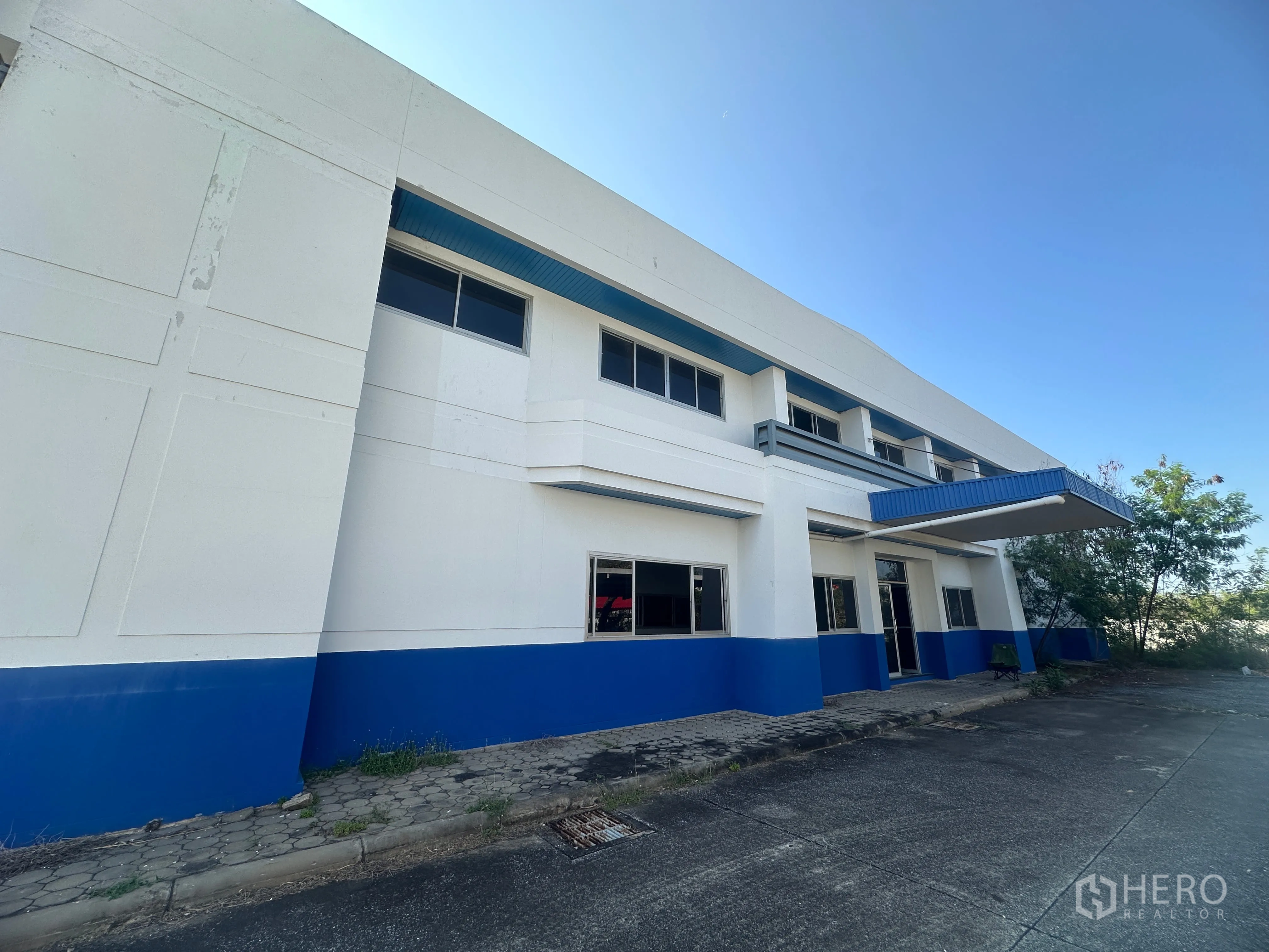 Factory for rent in Bang Pa-in, Phra Nakhon Si Ayutthaya - Front facade of the factory with blue trim and a covered entrance.